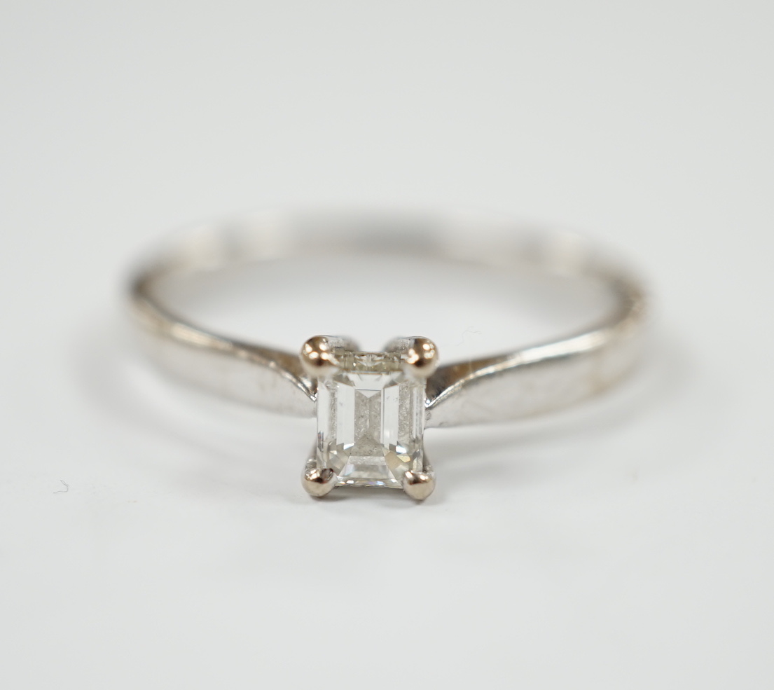 A modern 18ct white gold and solitaire emerald cut diamond set ring, size Q, gross weight 3.4 grams.